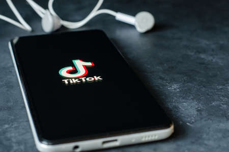 IZHEVSK, RUSSIA - October 03, 2020: Tik Tok logo on the Samsung smartphone screen. Tik Tok is a social network for video sharing. Copy space. Dark concrete backgroundのeditorial素材