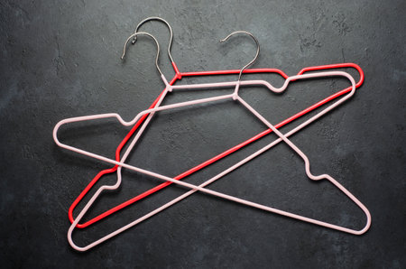 Red coat hangers on a dark concrete background. Copy spaceの写真素材