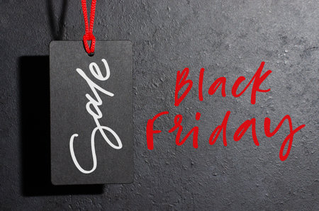 Black Friday - red handwritten inscription on a dark concrete background. The black tag. The concept...