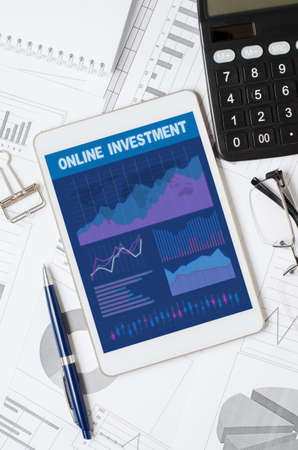 Online investment. Tablet with a mobile app with graphs and charts. Analysis of business processes or exchange tradingの写真素材