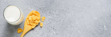 Corn flakes in a wooden spoon , milk in a glass Cup. The concept of a healthy Breakfast. Copy space.の写真素材