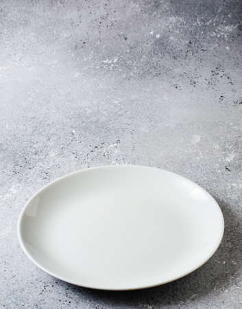 Blue concrete textured background for design with ceramic plate for food. Copy space