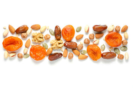 Nuts and dried fruits on a white background. Sources of antioxidants and vitamins. Healthy eating. Flat top view. For a healthy and vegetarian diet. Copy spaceの写真素材