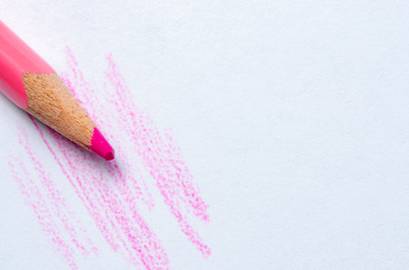 A red pencil draws strokes on white paper. Copy spaceの写真素材