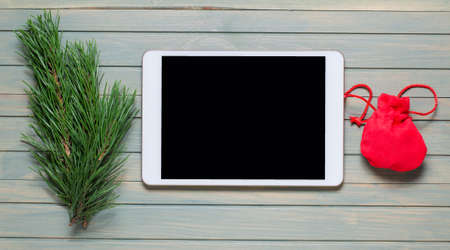 New year or Christmas composition. Wooden background. Tablet with an empty screen. Flat lay, top view, copy space.の写真素材