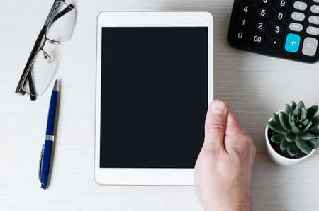 A tablet with an empty screen in a mans hands. The concept of mobile apps for business. Copy space