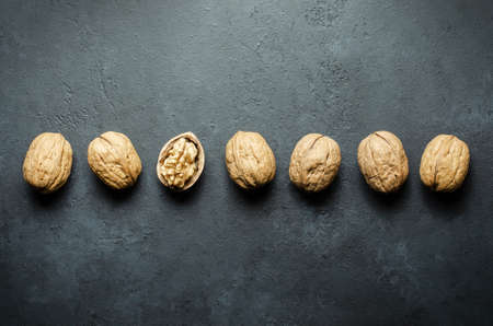 Walnuts on a dark concrete background. Nuts are a source of vegetable protein and vitamins. Flat top view, copy space.の写真素材