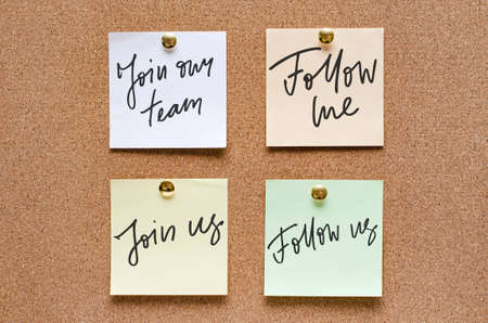 Paper notes with handwritten motivational inscriptions are pinned to a cork board.の写真素材