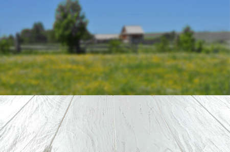 An empty white wooden table. Blurry summer or spring background.の写真素材