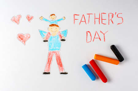 The father holds his son on his shoulders. Childrens drawing with crayons. The inscription fathers Day.の写真素材