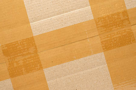 Brown tape on cardboard. The concept of transporting things, sending a donation or packing parcels. Copy space.の写真素材