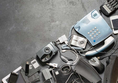 Old electronic devices on a dark background. The concept of recycling and disposal of electronic waste. Copy spaceの写真素材
