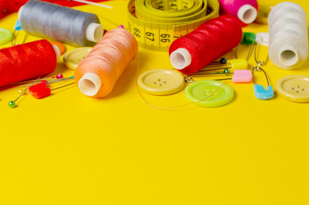 Sewing accessories on a yellow background. Closeup. Copy spaceの写真素材