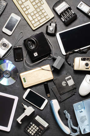Old electronic devices on a dark background. The concept of recycling and disposal of electronic waste.の写真素材