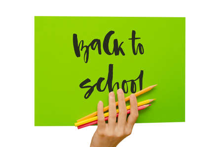 A colored poster in the girls hand. Handwritten inscription Back to school. Isolated on whiteの写真素材