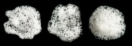 Texture of white foam on a black background. Cleansing mousse for the face or shaving foam or washing powder. Isolated on a black background.の写真素材