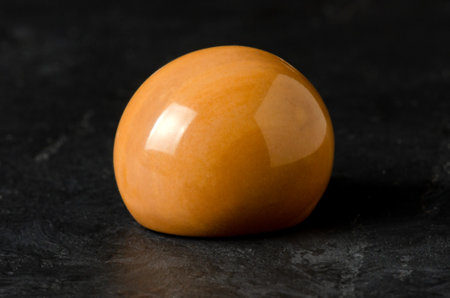 The stone is a mineral on a black concrete background. The concept of using minerals and crystals in astrology and alternative or complementary medicine.の写真素材