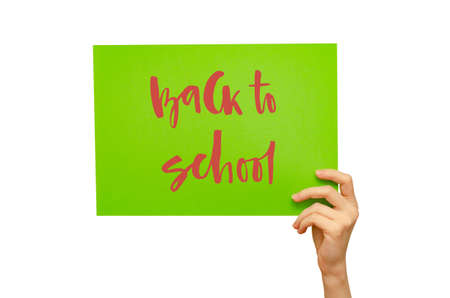 A colored poster in the girls hand. Handwritten inscription Back to school. Isolated on white