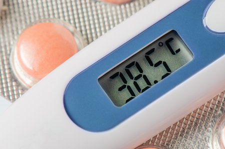 Medical electronic thermometer and tablets. High temperature. The concept of diagnosis of the...