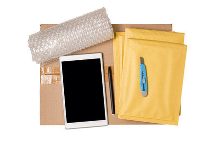 Cardboard box, smartphone, plastic wrap and packaging tools. The concept of packaging parcels for an...