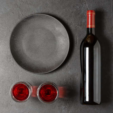 Red wine in a bottle. Black concrete background. Flat lay. Copy space.の写真素材
