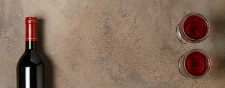 Red wine in a bottle. Brown concrete background. Flat lay. Copy space.の写真素材