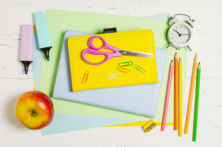 Childrens accessories for study, creativity and office supplies on a white wooden background. Back...