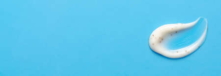 A sample of a cosmetic skin scrub with jojoba oil. Blue background. Copy space.の写真素材