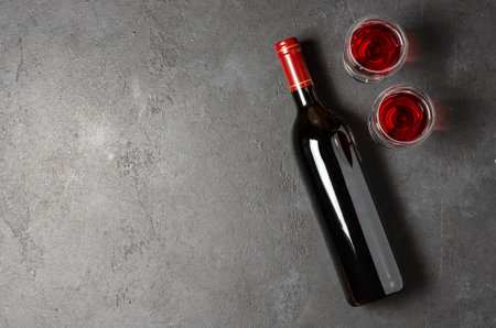 Red wine in a bottle. Black concrete background. Flat lay. Copy space.の写真素材