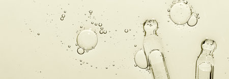 Two pipettes and a skin serum texture. Liquid body care product. Closeup.