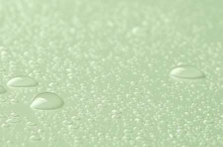 Drops of micellar water or cosmetic tonic on a green background. Close-up, macro photographyの写真素材