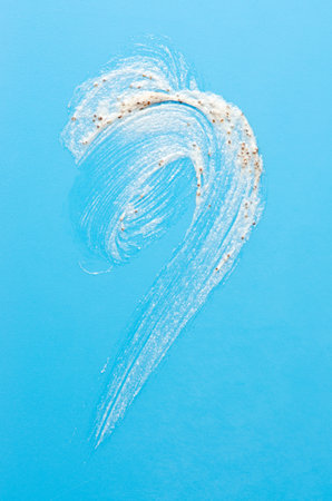 A sample of a cosmetic skin scrub with apricot pits. Blue background.の写真素材