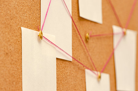 Blank paper notes are pinned to a cork board. The concept of detective investigation. Copy space.の写真素材