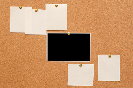 Blank paper notes and an empty photo are pinned to a cork board. The concept of detective...