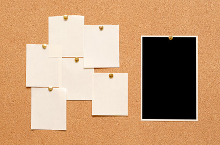 Blank paper notes and an empty photo are pinned to a cork board. The concept of detective investigation or a webinarの写真素材