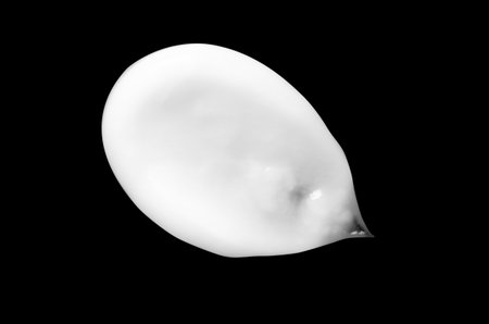 A sample of white body cosmetics on a black backgroundの写真素材