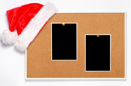 Blank photos are pinned to the board. Santa's hat on a cork boardの写真素材