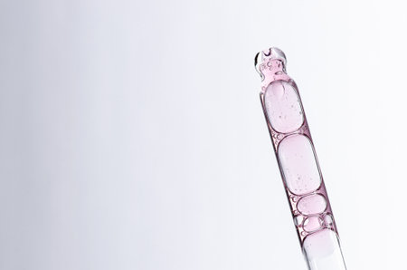 Skin serum in a pipette. A cosmetic product for body care. White background. Copy space.