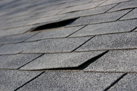 Roofing trouble - damage to shingles that needs repair - home maintenance series. Narrow DOFの写真素材