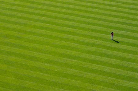 A baseball player stands alone out in the outfieldの写真素材