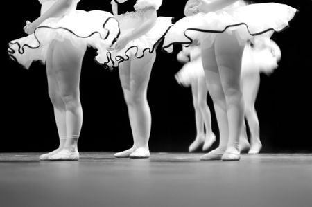 Performing on stage, a group of young dancers show off their talent and bright costumes - image highlights a narrow depth of fieldの写真素材