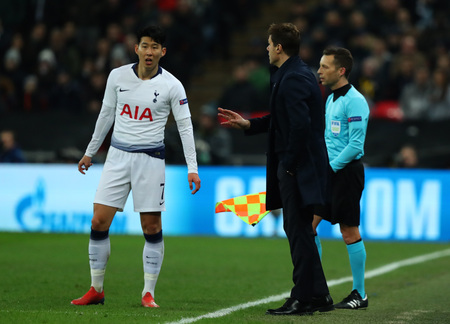 LONDON, ENGLAND - FEBRUARY 13 2019: Son Heung-Min of Tottenham gets instructions from manager Mauricio Pochettino during the Champions League match between Tottenham Hotspur and Borussia Dortmund at Wembley Stadium, London.のeditorial素材