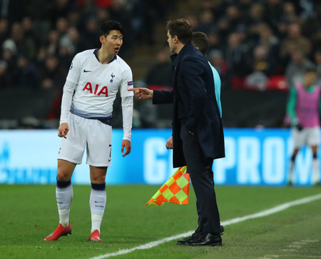 LONDON, ENGLAND - FEBRUARY 13 2019: Son Heung-Min of Tottenham gets instructions from manager Mauricio Pochettino during the Champions League match between Tottenham Hotspur and Borussia Dortmund at Wembley Stadium, London.のeditorial素材