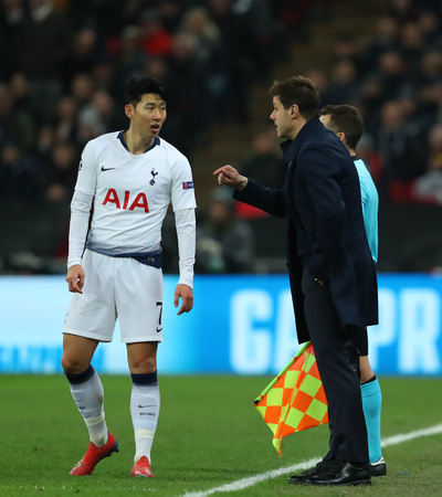 LONDON, ENGLAND - FEBRUARY 13 2019: Son Heung-Min of Tottenham gets instructions from manager Mauricio Pochettino during the Champions League match between Tottenham Hotspur and Borussia Dortmund at Wembley Stadium, London.のeditorial素材