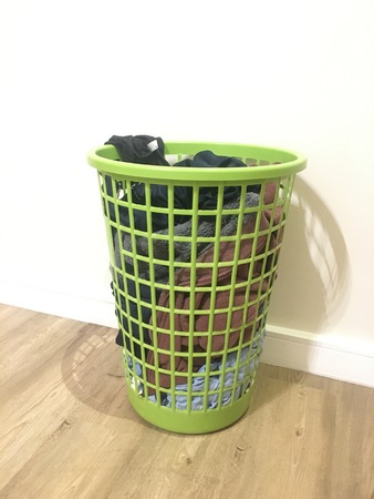 Full green wash basket on laminate floorの写真素材