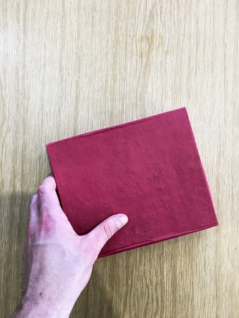 What is inside this red gift box on this wooden table.の写真素材