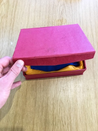 Opening a brightly colored gift box on a wooden table.の写真素材