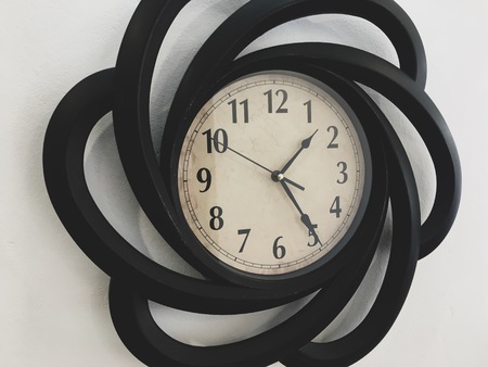 Pretty large black clock on a white wall, half past two in the afternoon.の写真素材