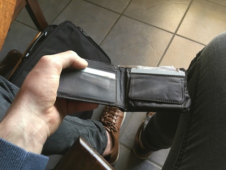Man checking his leather wallet to see if he can afford the leather shoes.の写真素材