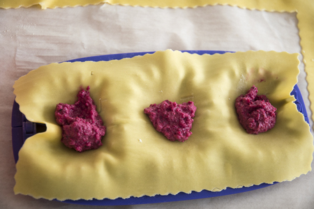 three homemade tortellini filled with red beetの写真素材